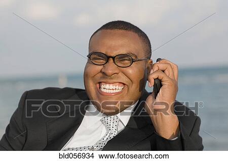 Picture - African businessman talking on cell phone. Fotosearch