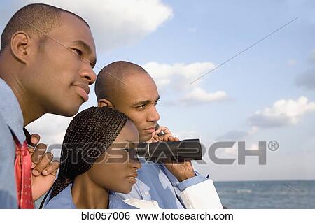Stock Photograph - African businesspeople looking through binoculars. Fotosearch