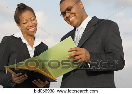 Stock Photo - African businesspeople reading paperwork. Fotosearch