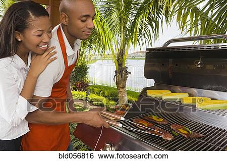 Stock Photograph - African couple barbecuing. Fotosearch