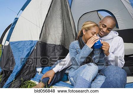 Stock Photo - African couple drinking coffee at campsite. Fotosearch