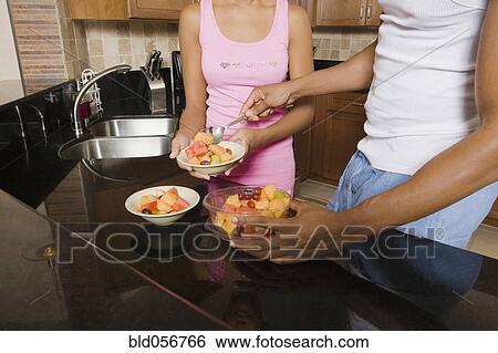 Stock Photograph - African couple eating fruit salad. Fotosearch