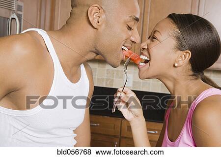 African couple eating piece of fruit View Large Photo Image Stock Photo - African couple eating piece of fruit. Fotosearch