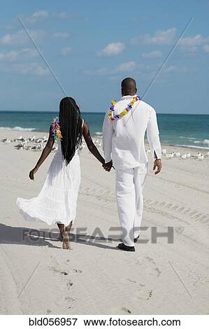 Stock Photo - African couple holding hands at beach. Fotosearch
