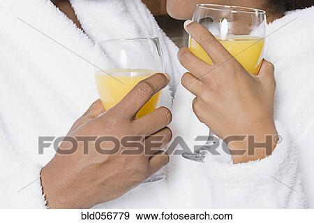 Stock Photo - African couple holding orange juice. Fotosearch