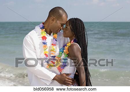 Stock Photo - African couple hugging at beach. Fotosearch