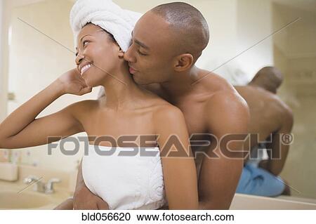 Stock Image - African couple hugging in bathroom. Fotosearch