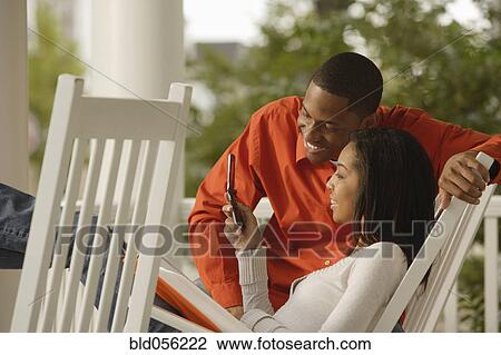 Stock Image - African couple looking at cell phone. Fotosearch