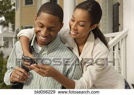 Stock Photo - African couple looking at cell phone. Fotosearch