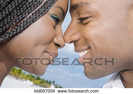 Picture - African couple smiling at each other. Fotosearch