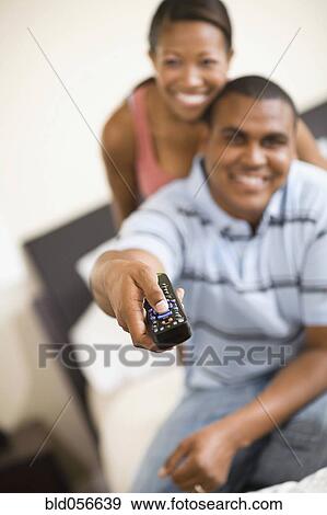 Stock Photo - African couple watching television. Fotosearch