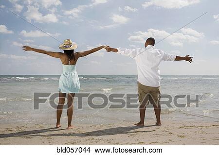 African couple with arms outstretched at beach View Large Photo Image Picture - African couple with arms outstretched at beach. Fotosearch
