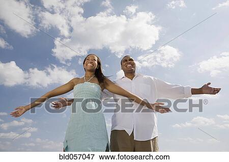 Stock Photo - African couple with arms outstretched. Fotosearch
