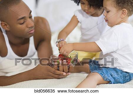 African father and children eating fruit View Large Photo Image Stock Photography - African father and children eating fruit. Fotosearch