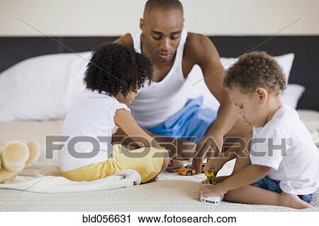 Stock Image - African father playing with children. Fotosearch