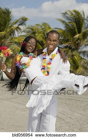 Picture - African man carrying wife. Fotosearch