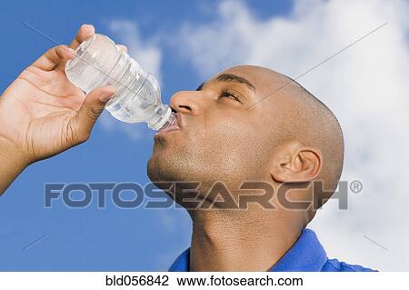 Stock Image - African man drinking water. Fotosearch