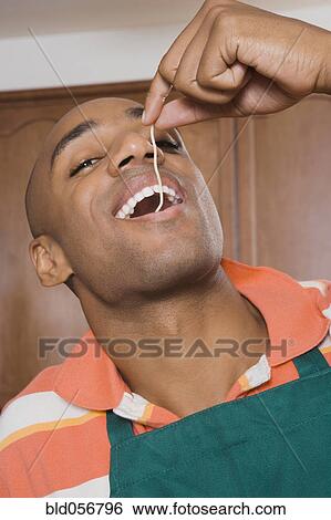 African man eating piece of spaghetti View Large Photo Image Stock Photograph - African man eating piece of spaghetti. Fotosearch