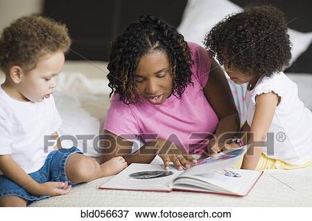 Stock Photo - African mother reading to children. Fotosearch