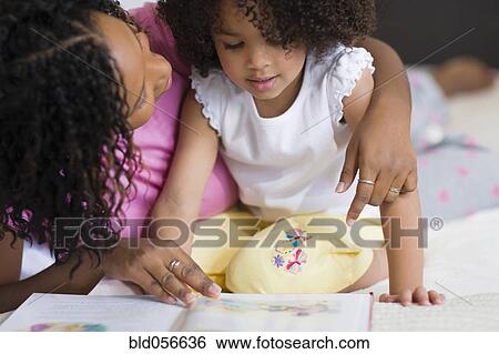 African mother reading to daughter View Large Photo Image Stock Photograph - African mother reading to daughter. Fotosearch