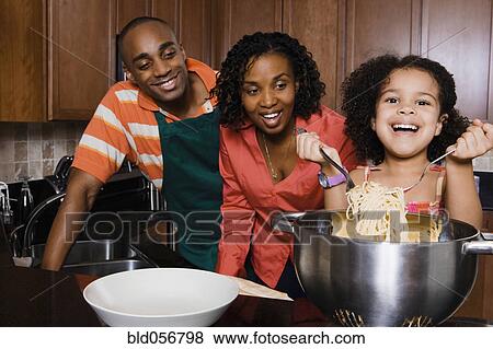 African parents watching daughter serve spaghetti View Large Photo Image Stock Photo - African parents watching daughter serve spaghetti. Fotosearch