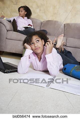 Picture - African twin sisters doing homework. Fotosearch