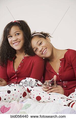 Stock Image - African twin sisters hugging. Fotosearch