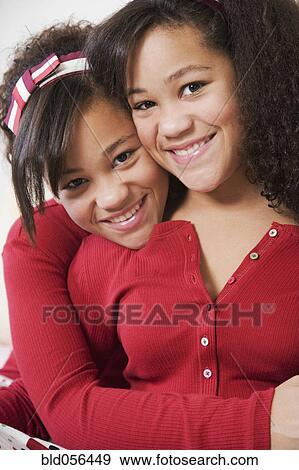 Stock Photo - African twin sisters hugging. Fotosearch