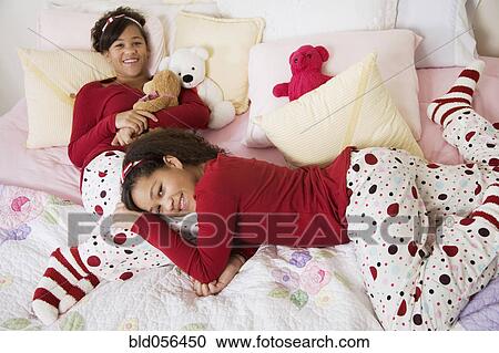 African twin sisters laying on bed View Large Photo Image Stock Image - African twin sisters laying on bed. Fotosearch