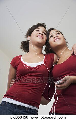 African twin sisters listening to same mp3 player View Large Photo Image Stock Photograph - African twin sisters listening to same mp3 player. Fotosearch