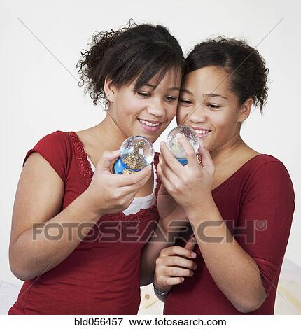 African twin sisters looking at snow globes View Large Photo Image Stock Photo - African twin sisters looking at snow globes. Fotosearch