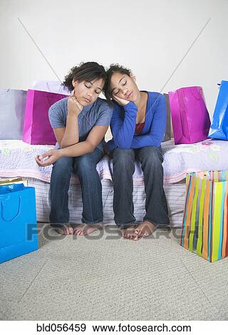 Stock Photo - African twin sisters looking bored. Fotosearch