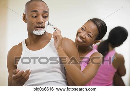 Stock Photograph - African woman helping husband shave . Fotosearch