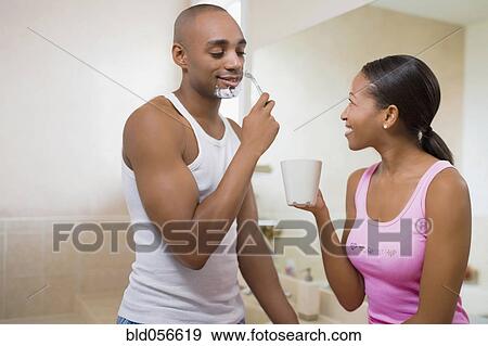 Stock Photo - African woman watching husband shave. Fotosearch