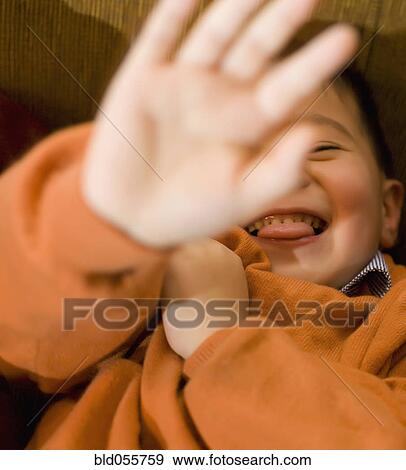 Stock Photo - Asian boy holding hand in front of face. Fotosearch