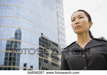 Asian businesswoman in front of high-rise View Large Photo Image Stock Photo - Asian businesswoman in front of high-rise. Fotosearch