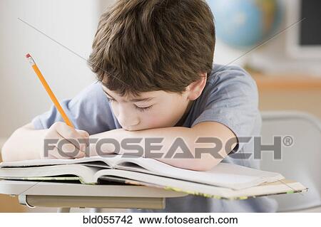 Stock Image - Hispanic boy doing homework. Fotosearch