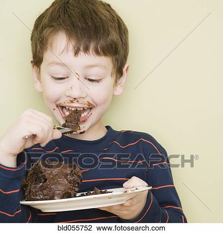 Stock Image - Hispanic boy eating cake. Fotosearch