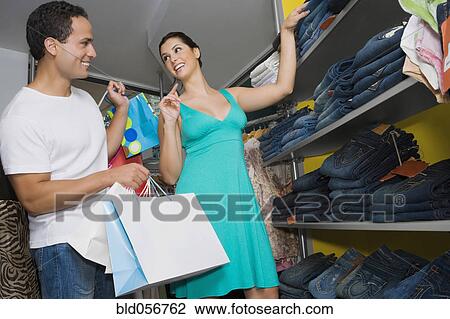 Stock Image - Hispanic couple clothing shopping. Fotosearch