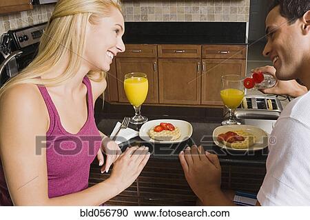 Stock Image - Hispanic couple eating breakfast. Fotosearch