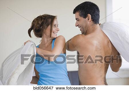 Stock Photo - Hispanic couple having pillow fight. Fotosearch