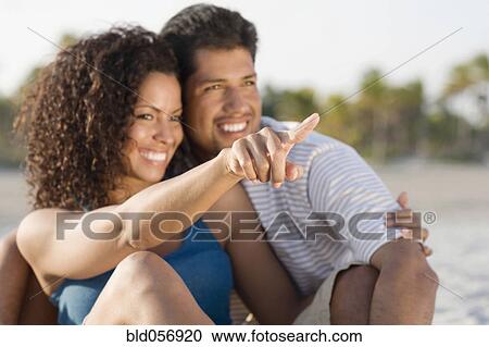 Hispanic couple hugging and pointing View Large Photo Image Stock Image - Hispanic couple hugging and pointing. Fotosearch