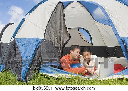 Hispanic couple looking at laptop in tent View Large Photo Image Stock Image - Hispanic couple looking at laptop in tent. Fotosearch
