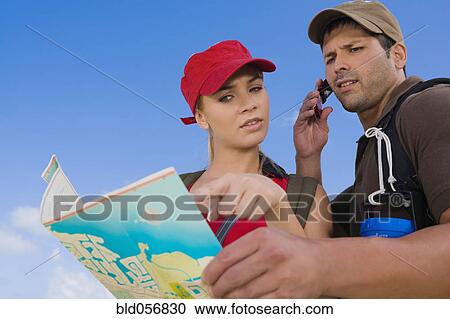 Stock Image - Hispanic couple looking at map. Fotosearch