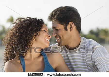 Stock Image - Hispanic couple smiling at each other. Fotosearch