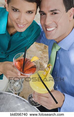 Stock Image - Hispanic couple toasting with cocktails. Fotosearch