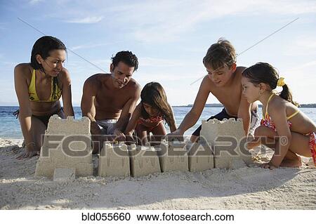 Hispanic family building sand castle View Large Photo Image Stock Image - Hispanic family building sand castle. Fotosearch