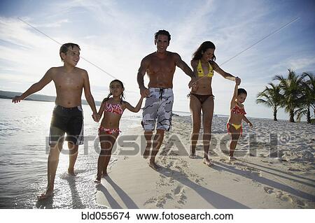 Picture - Hispanic family holding hands at beach. Fotosearch