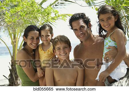 Stock Photography - Hispanic family hugging at beach. Fotosearch