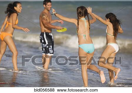 Stock Photo - Hispanic family playing at beach. Fotosearch